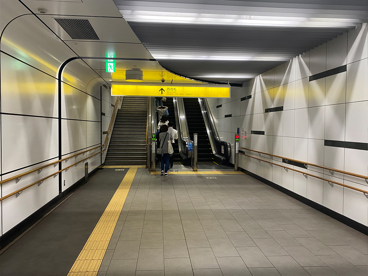 西改札の方向へ進むと、すぐに次のエスカレーターがありますので、そちらへ向かってください。