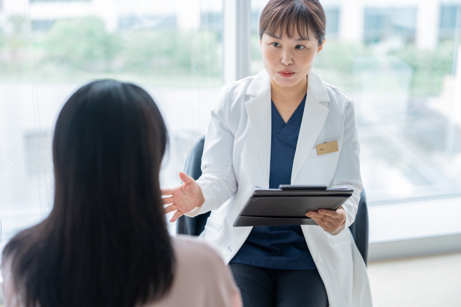 女性医師が女性患者にFAGAについて説明している様子